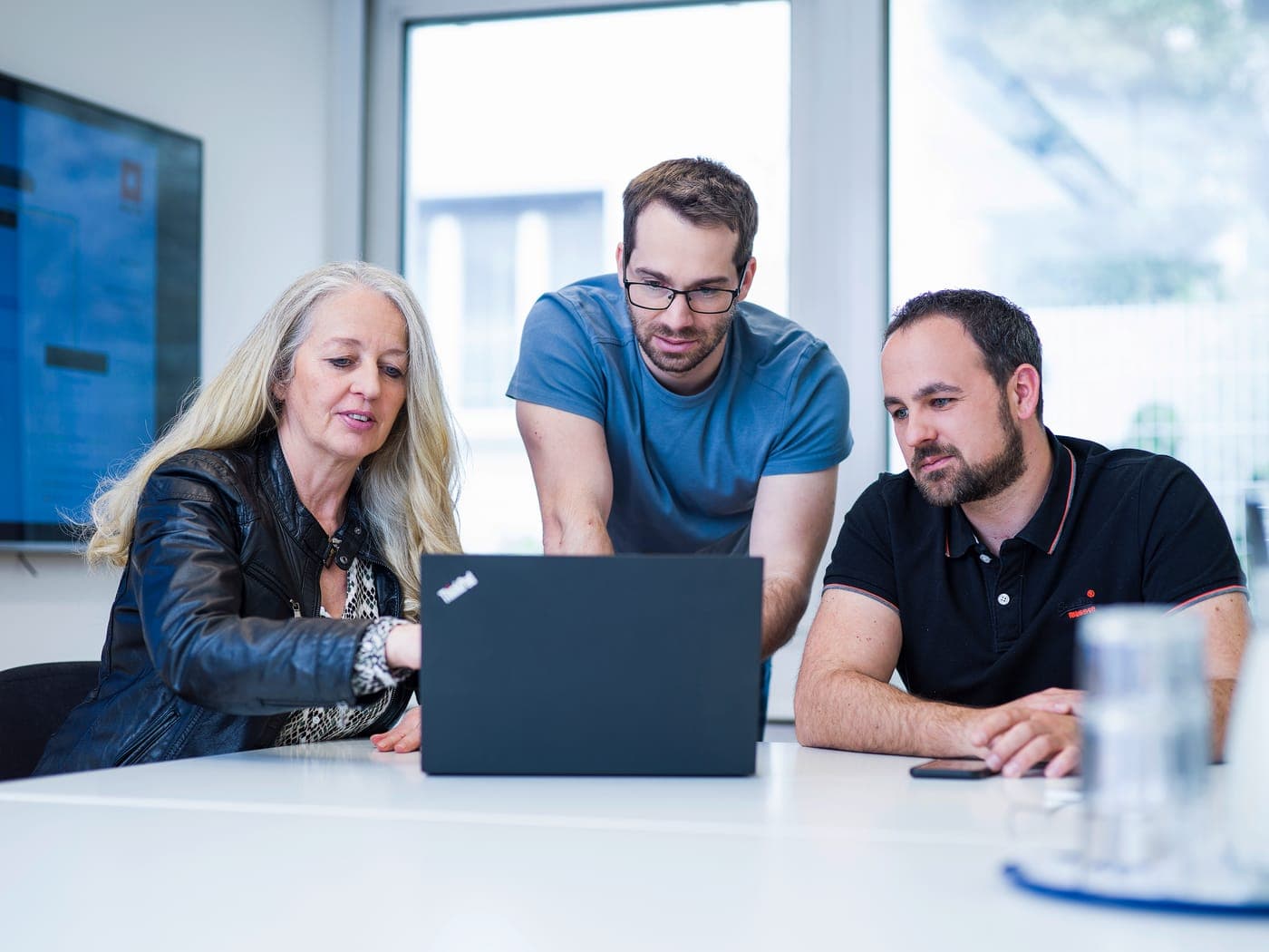 Drei Kollegen besprechen ein Konzept am Lenovo-Laptop